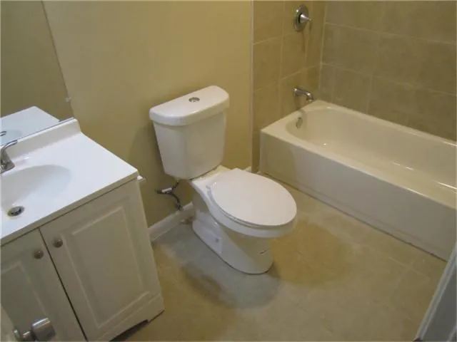 a white toilet sitting next to a bathroom sink and vanity