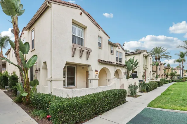 a front view of a white building with a yard