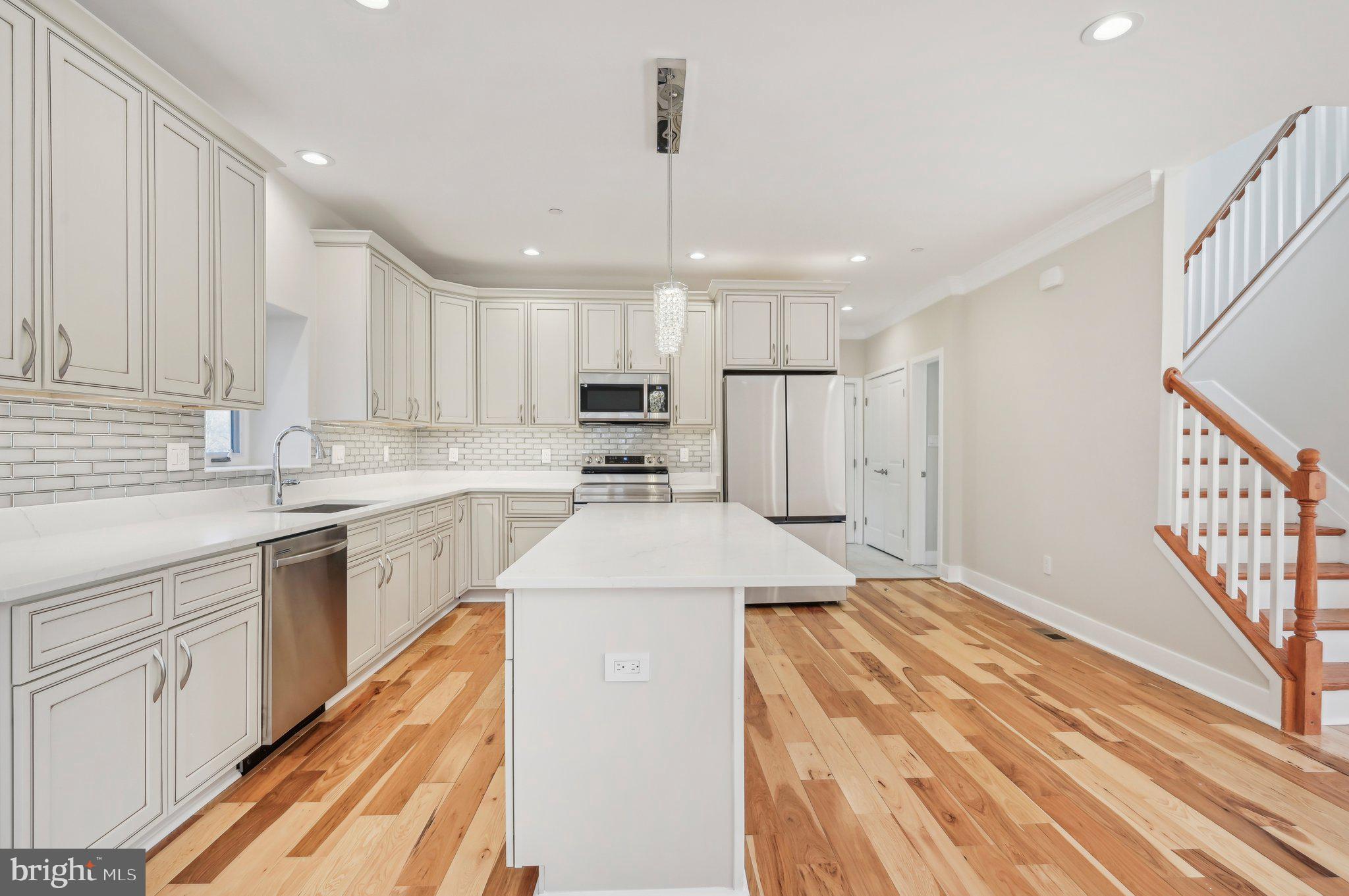11990 Hall Shop Road Clarksville, MD 21029 - Photo 19 of 64 a kitchen with kitchen island a sink appliances cabinets and a counter top space