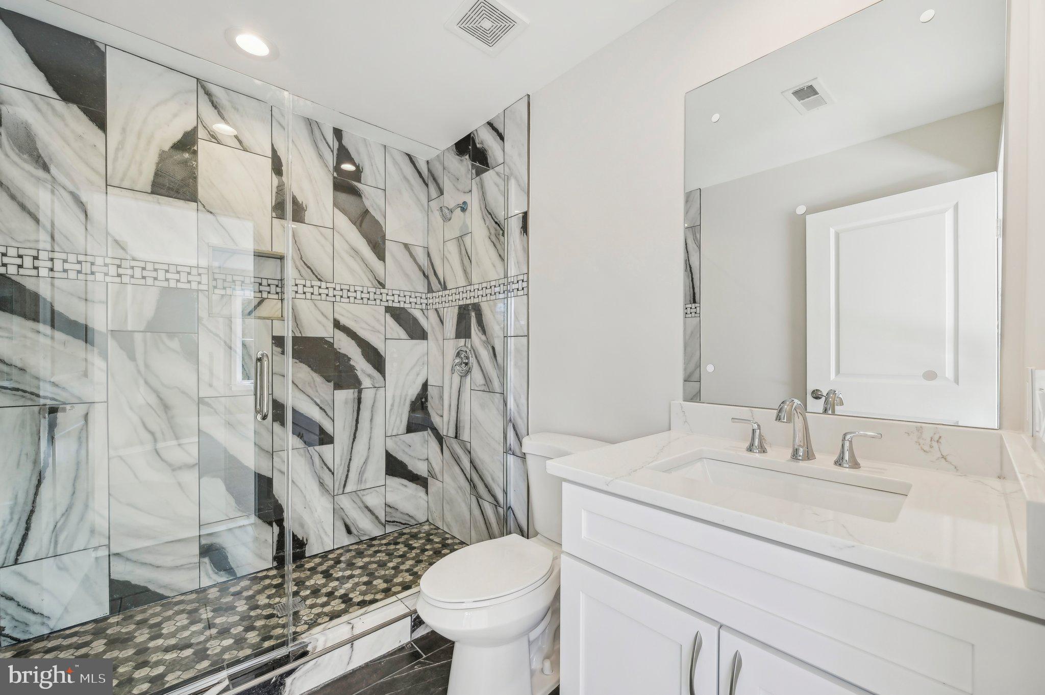 11990 Hall Shop Road Clarksville, MD 21029 - Photo 33 of 64 a bathroom with a granite countertop sink a toilet and a shower