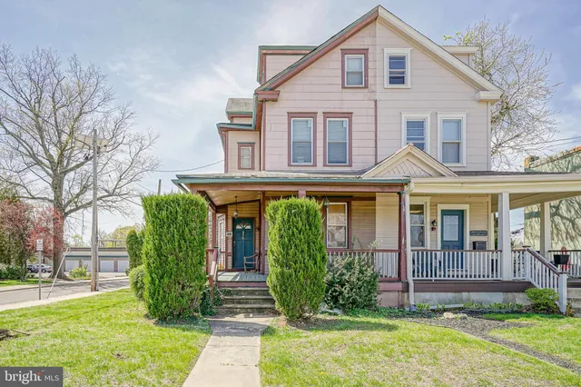 a view of a house with brick walls and a yard with plants