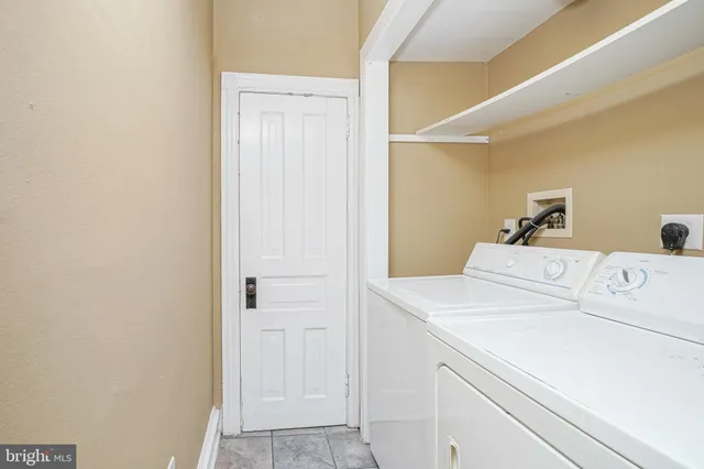 a view of an empty room with wooden floor and a bathroom