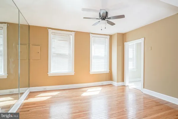 a view of an empty room with window and wooden floor