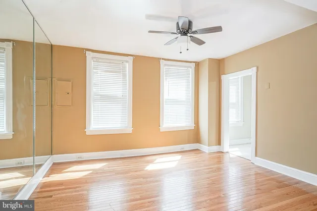 a view of an empty room with window and wooden floor