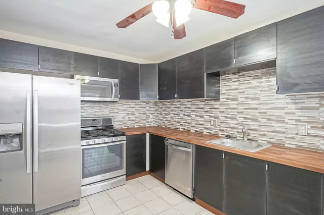 a kitchen with stainless steel appliances granite countertop a sink and a stove top oven