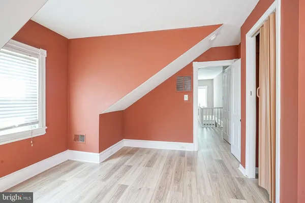 a view of a hallway with wooden floor and closet
