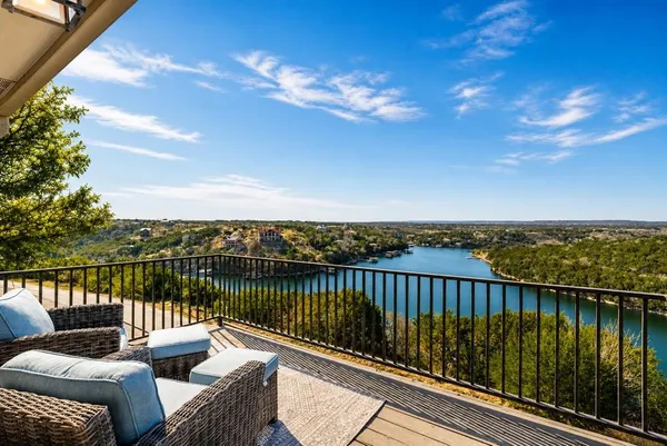 a view of a balcony with wooden floor and lake view