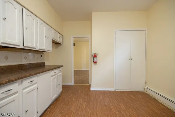 an empty room with wooden floor and cabinet