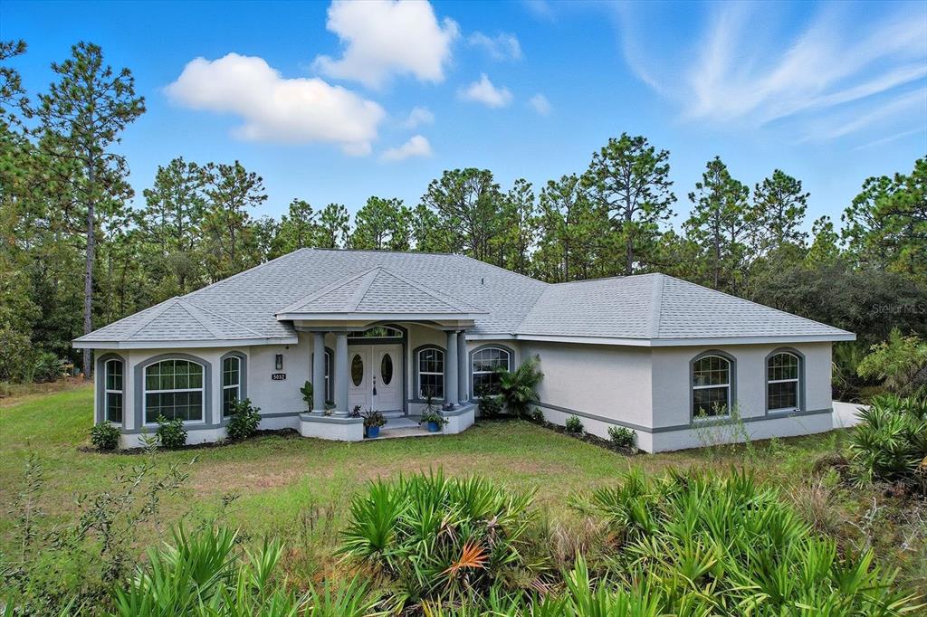 a front view of a house with a garden