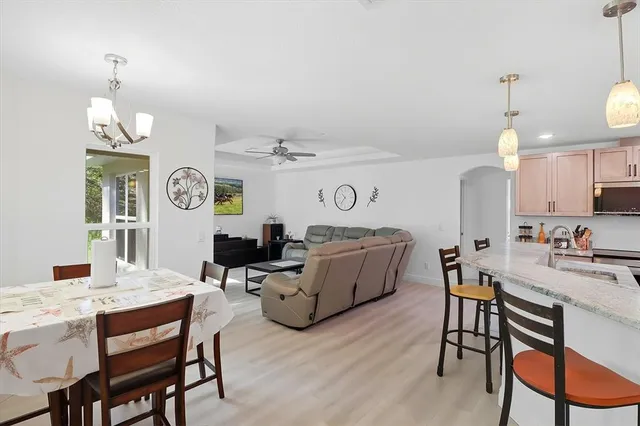 a kitchen with stainless steel appliances kitchen island granite countertop a sink and a refrigerator