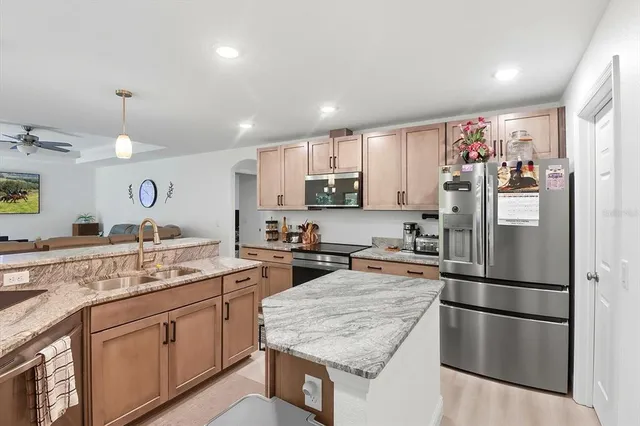 a kitchen with stainless steel appliances granite countertop a refrigerator stove and sink