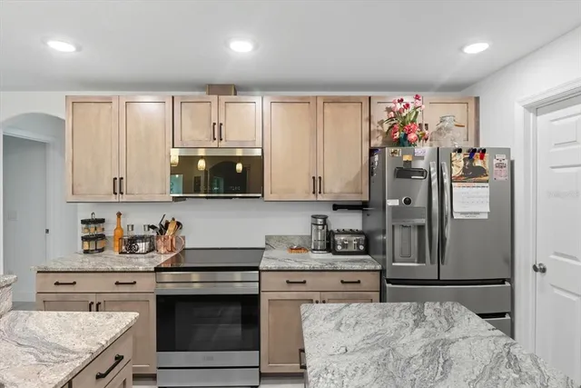 a kitchen with stainless steel appliances granite countertop a sink stove and refrigerator