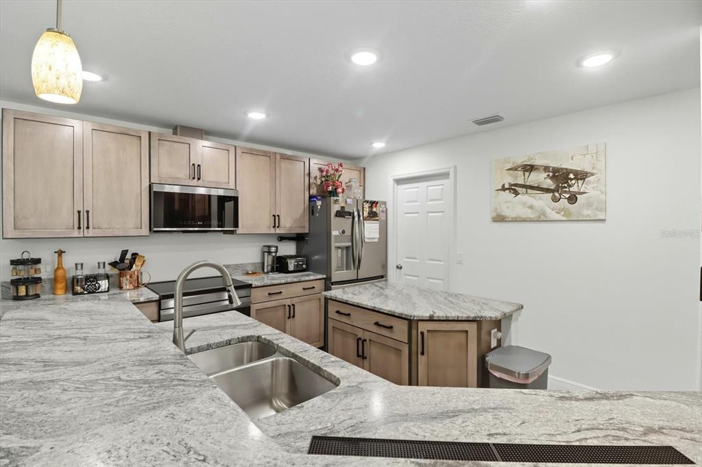 5032 North Crossgate Point Beverly Hills, FL 34465 - Photo 18 of 43 a kitchen with stainless steel appliances granite countertop a sink stove and refrigerator