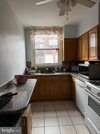 a kitchen with a stove a sink a counter top space and cabinets