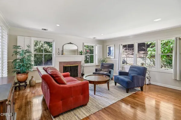 a living room with furniture fireplace and a large window