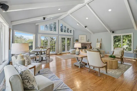 a living room with furniture fireplace and a large window