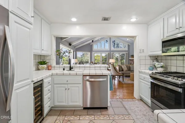 a kitchen with stainless steel appliances a stove refrigerator sink and cabinets