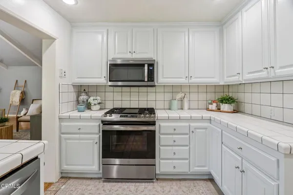 a kitchen with white cabinets and stainless steel appliances
