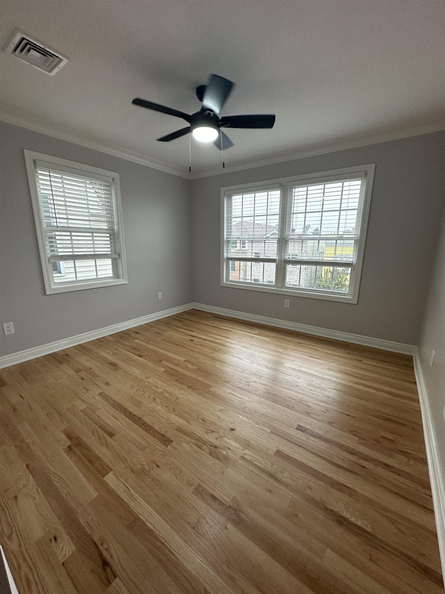 24 New Street, Unit 2 Bayonne, NJ 07002 - Photo 19 of 21 a view of an empty room with wooden floor and a window