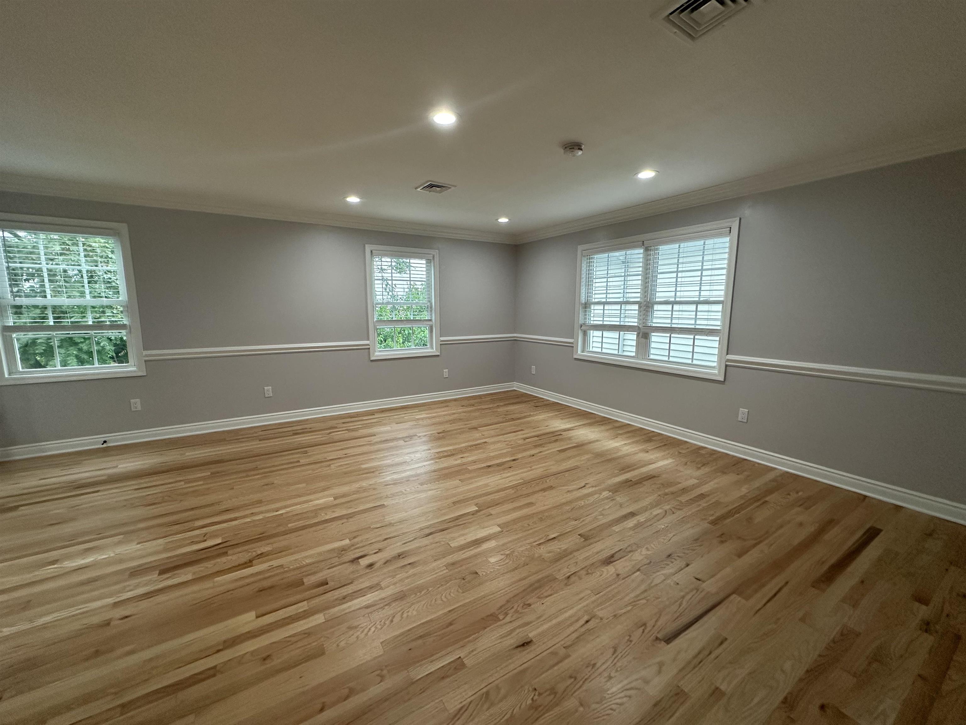 24 New Street, Unit 2 Bayonne, NJ 07002 - Photo 5 of 21 an empty room with wooden floor and windows