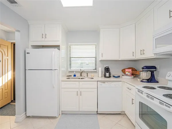 a kitchen with white cabinets and white appliances