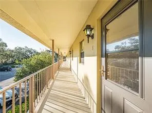 a view of a balcony with wooden floor and door