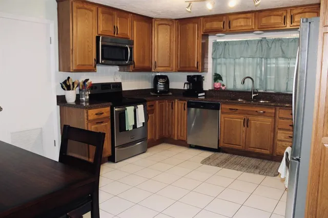 a kitchen with stainless steel appliances granite countertop a sink stove and microwave