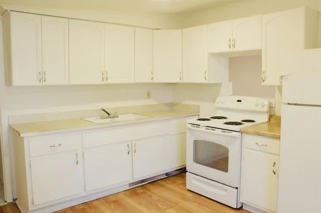 a kitchen with white cabinets and white appliances