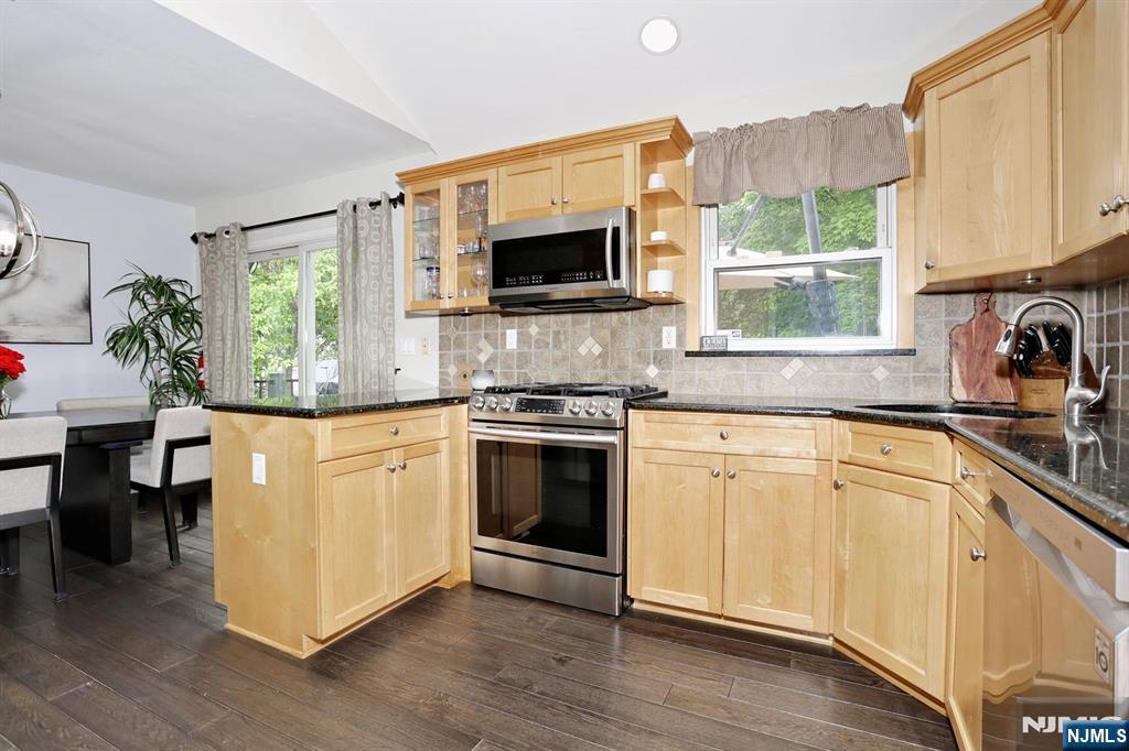 30 Brookfield Road Dumont, NJ 07628 - Photo 12 of 50 a kitchen with stainless steel appliances white cabinets a sink a stove a microwave and wooden floors