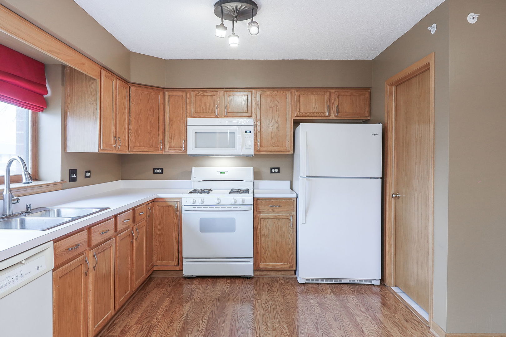 18100 Rita Road, Unit 1B Tinley Park, IL 60477 - Photo 11 of 21 a kitchen with a sink a refrigerator and white cabinets
