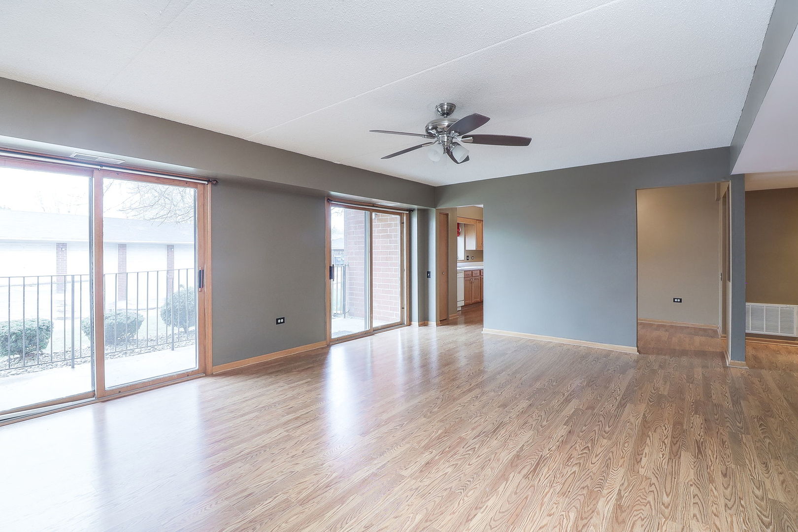 18100 Rita Road, Unit 1B Tinley Park, IL 60477 - Photo 3 of 21 a view of an empty room with a window and wooden floor
