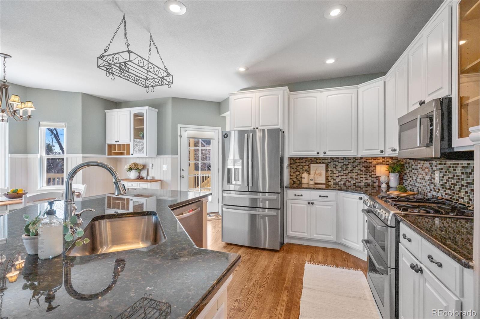 1356 Northpark Drive Lafayette, CO 80026 - Photo 13 of 35 a kitchen with stainless steel appliances granite countertop a sink a stove a refrigerator cabinets and a dining table