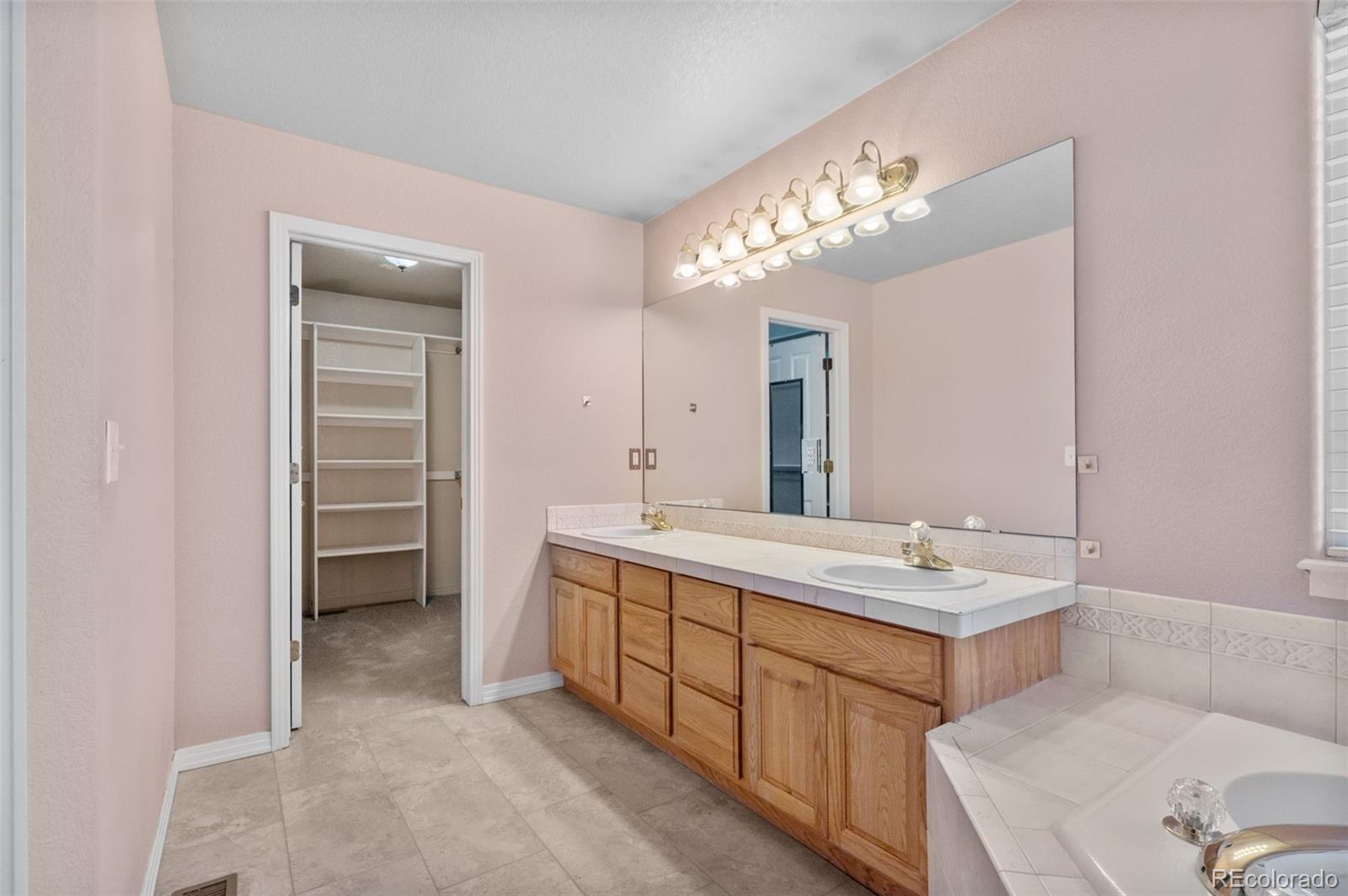1356 Northpark Drive Lafayette, CO 80026 - Photo 18 of 35 a spacious bathroom with a double vanity sink and a mirror