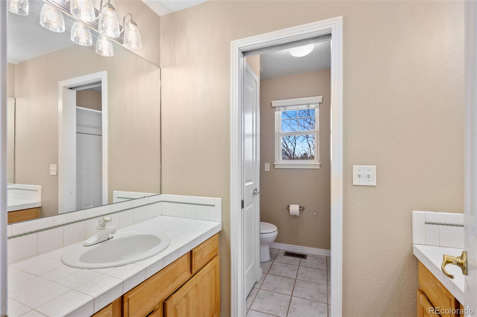 1356 Northpark Drive Lafayette, CO 80026 - Photo 20 of 35 a bathroom with a granite countertop sink toilet and shower