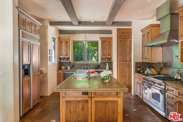 a kitchen with kitchen island granite countertop a sink appliances and cabinets