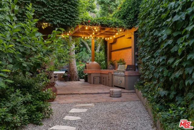 a front view of a house with plants and trees