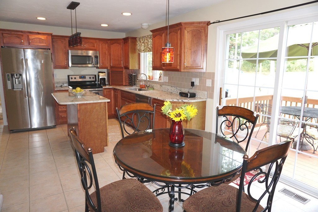 84 Fairview Park Road Sturbridge, MA 01566 - Photo 11 of 30 a kitchen with stainless steel appliances granite countertop a stove a refrigerator a kitchen island a table and chairs