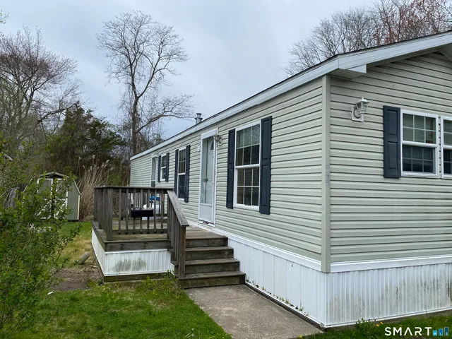 a view of a house with a yard and wooden fence