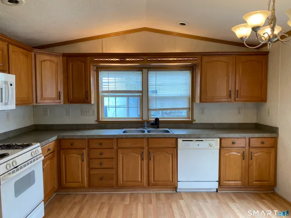 a kitchen with granite countertop a stove cabinets and wooden floor