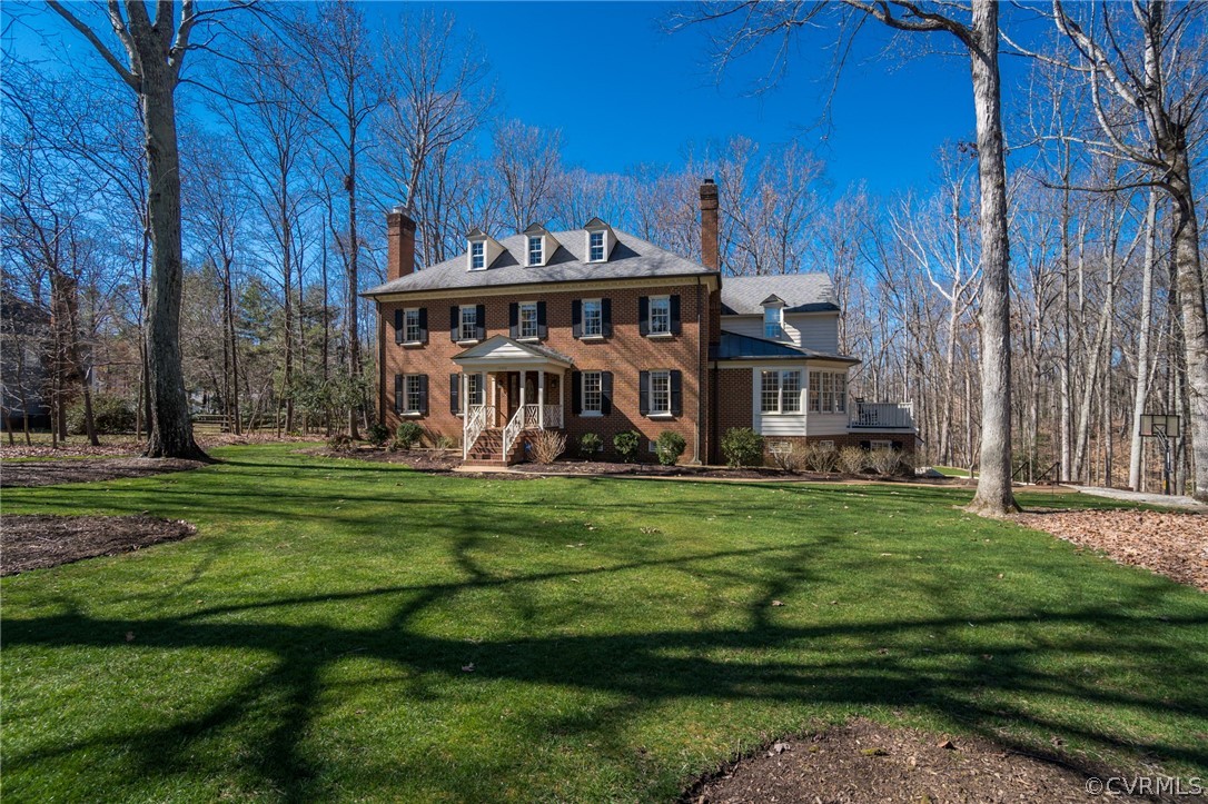 a view of a big house with a big yard and large trees