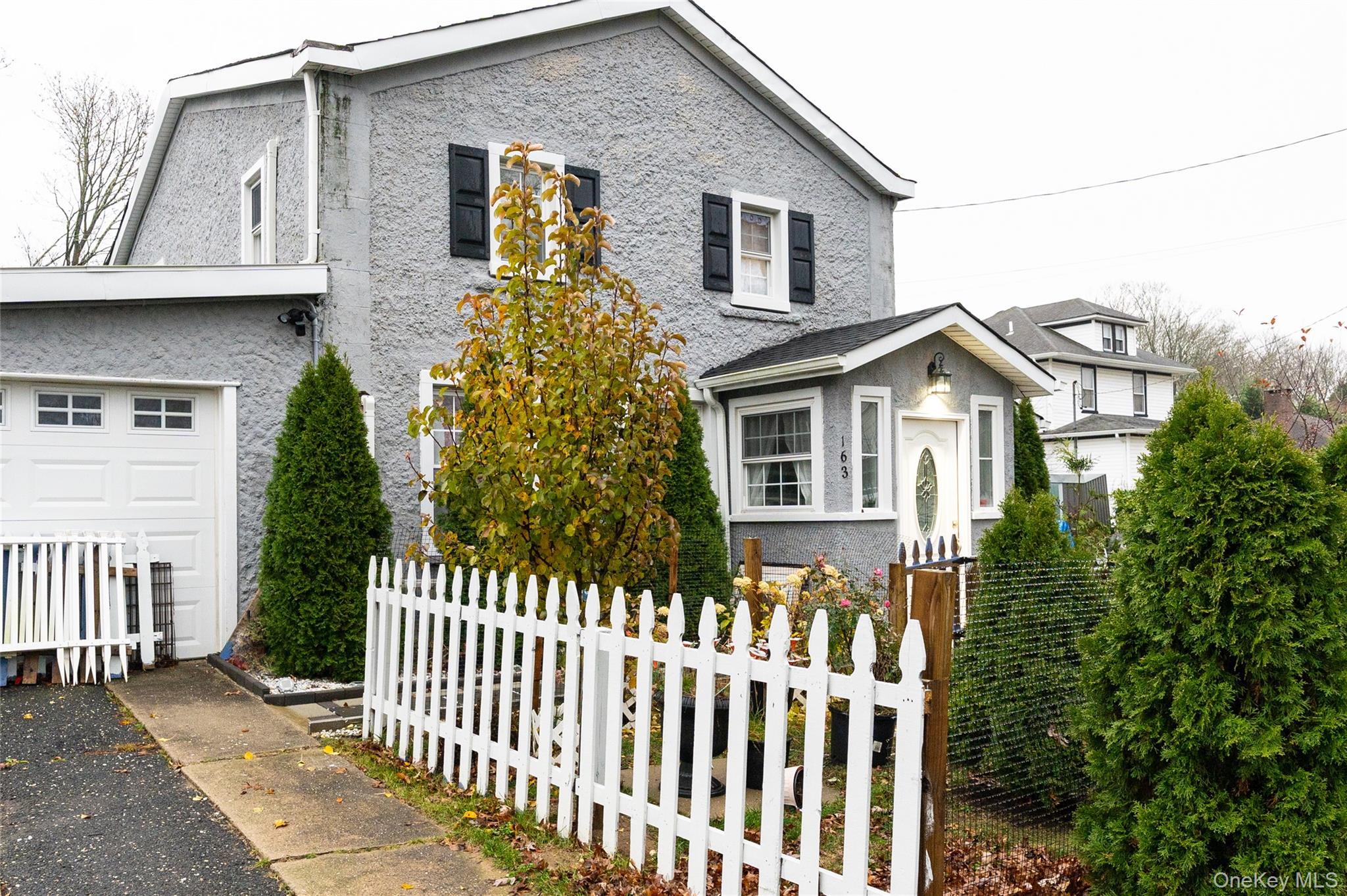 163 Orchard Road East Patchogue, NY 11772 - Photo 2 of 26 View of front of home featuring a fenced front yard and stucco siding