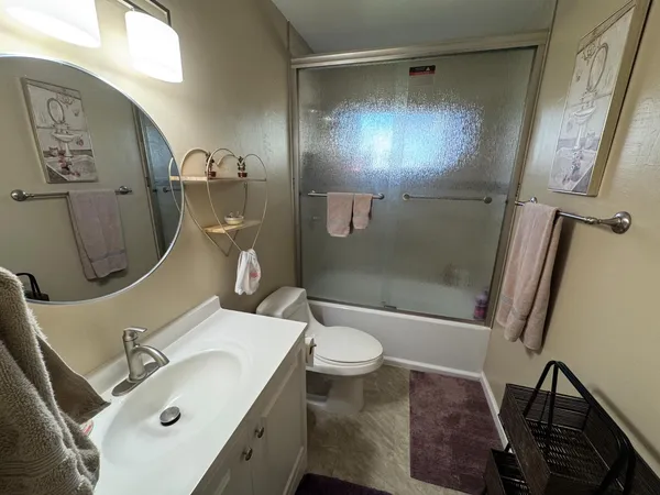 a bathroom with a sink mirror vanity and toilet