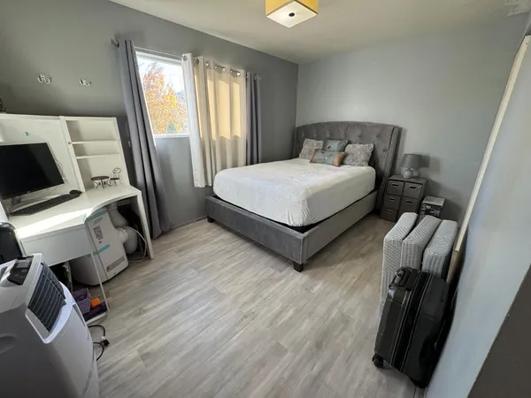 a bedroom with a bed tv and a window