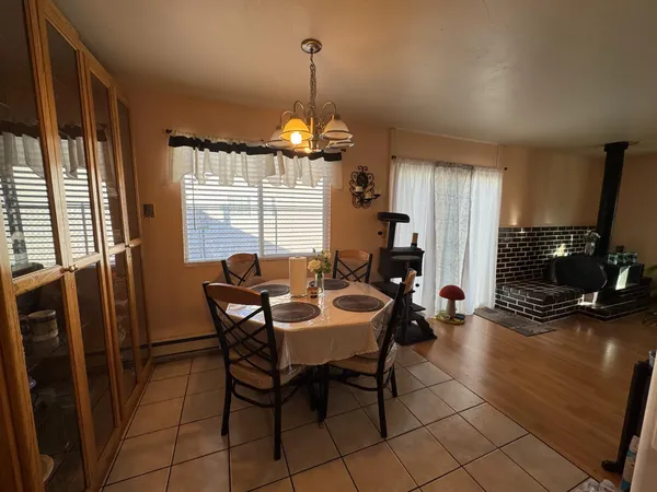 a dining room with furniture a chandelier and window