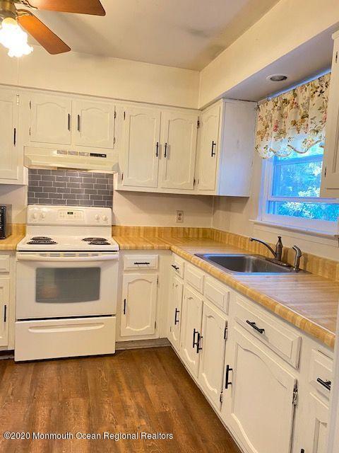 136 B Sunset Road Whiting, NJ 08759 - Photo 7 of 16 a kitchen with granite countertop white cabinets and white appliances