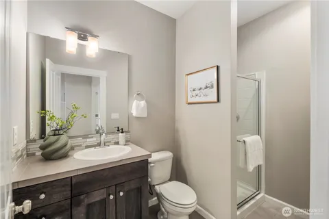 a bathroom with a toilet a sink a light fixture and a mirror