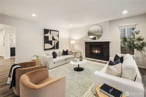 a living room with furniture a fireplace and a potted plant