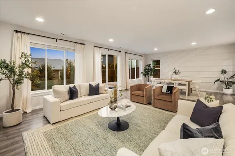 a living room with furniture kitchen view and large windows