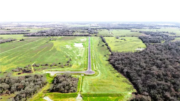 an aerial view of a golf course with a lake view