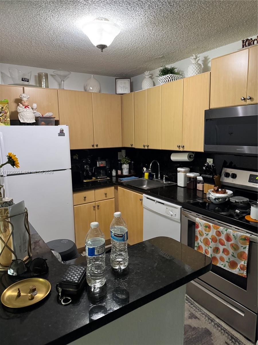 7155 Northwest 179th Street, Unit 112 Hialeah, FL 33015 - Photo 1 of 7 a kitchen with sink a stove and cabinets